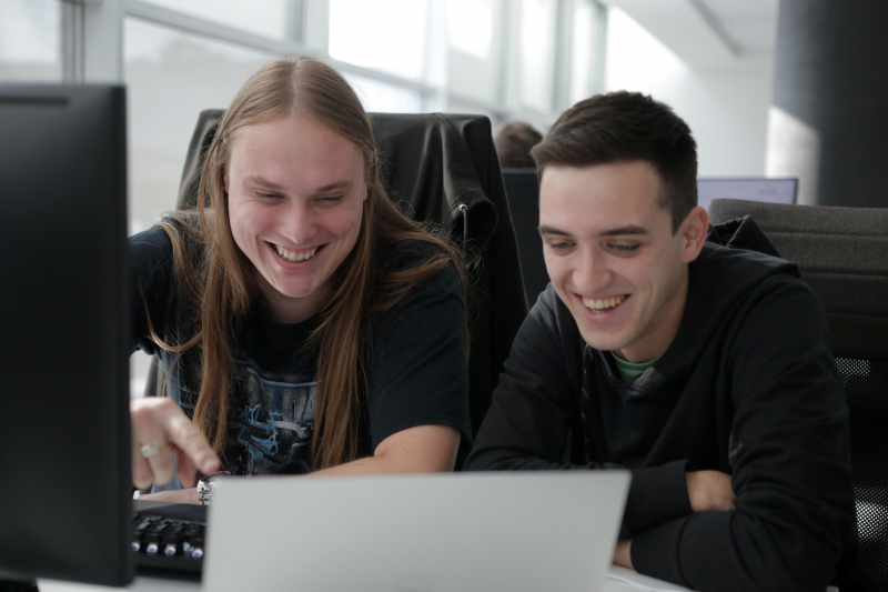 Developers Domen and Nace working and laughing in Celje office